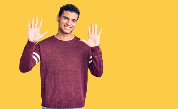 身穿休闲装的西班牙裔英俊年轻人面带微笑 满面春风 用手指指点着十号 — 图库照片