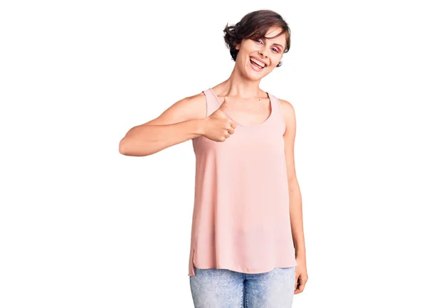 漂亮的年轻女子 穿着休闲装 无袖衬衫 手拿着快乐的大拇指做着快乐的手势 赞成的表情看着相机显示的成功 — 图库照片