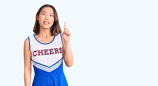 年轻美丽的中国姑娘身穿啦啦队队长制服 带着第一指尖 面带微笑 自信而快乐 — 图库照片