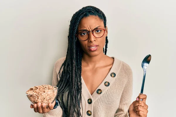 アフリカ系アメリカ人の女性は 穀物全体の穀物を健康に食べ 混乱した表情をしています 疑わしい概念 — ストック写真