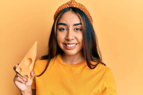 Молодая Латинская Женщина Ест Сыр Эмменталь Выглядит Позитивно Счастливо Стоя — стоковое фото