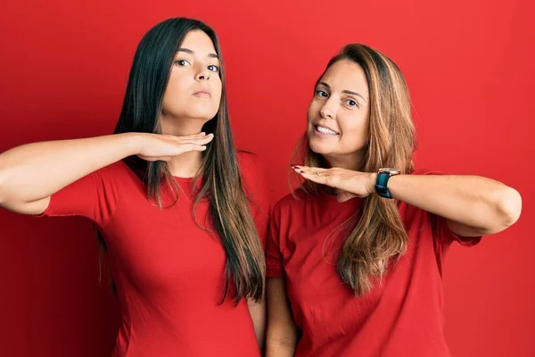 Família Hispânica Mãe Filha Vestindo Roupas Casuais Sobre Fundo Vermelho — Fotografia de Stock