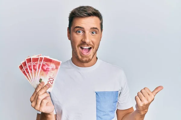 Bonito Homem Caucasiano Segurando Shekels Israel Apontando Polegar Até Lado — Fotografia de Stock