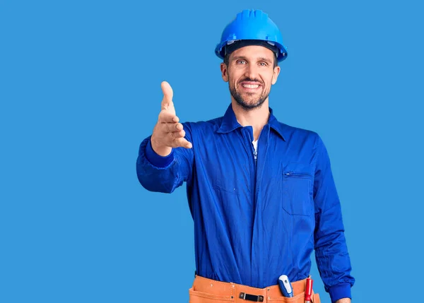 Jovem Homem Bonito Vestindo Uniforme Trabalhador Hardhat Sorrindo Amigável Oferecendo — Fotografia de Stock