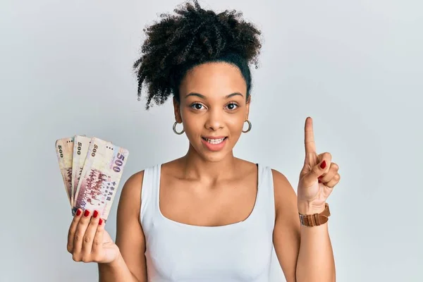 500台湾ドルの新しい紙幣を持っている若いアフリカ系アメリカ人の女の子は 幸せな顔 ナンバーワンで指を指しているアイデアや質問で笑顔 — ストック写真