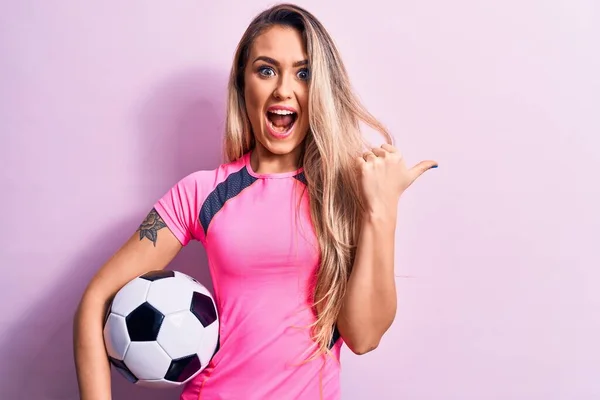 Genç Sarışın Bir Kadın Futbol Topunu Pembe Arka Planda Tutarak — Stok fotoğraf