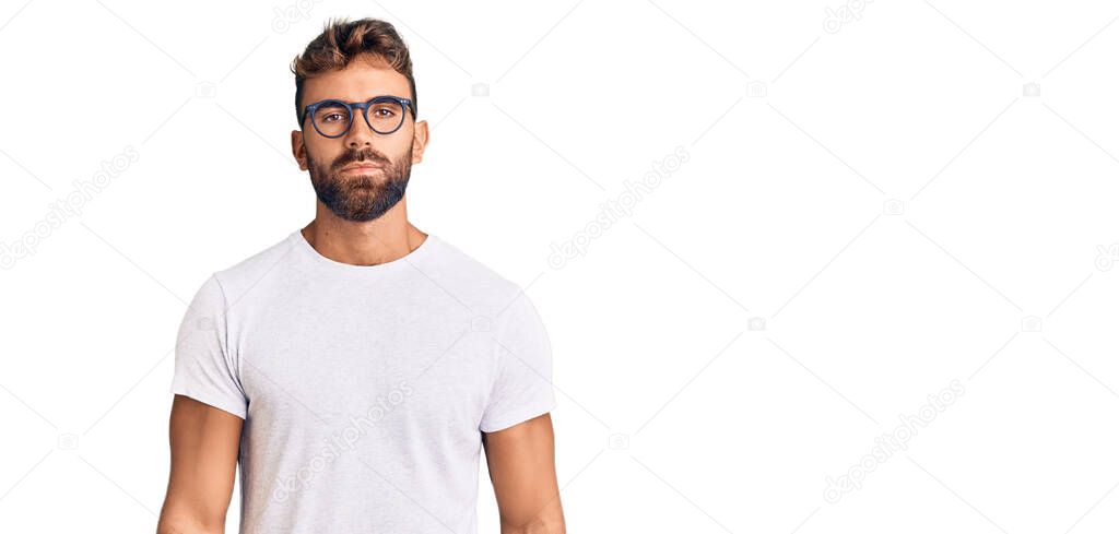 Young hispanic man wearing casual clothes and glasses relaxed with serious expression on face. simple and natural looking at the camera. 
