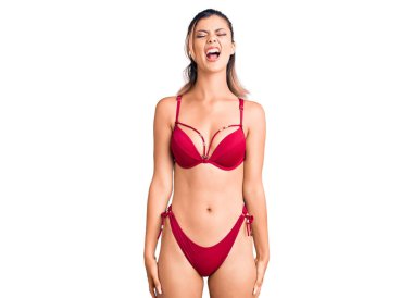 Genç, güzel bir kadın bikini giyiyor kızgın ve deli gibi bağırıyor sinirli ve öfkeli, öfkeyle bağırıyor. öfke ve agresif konsept. 