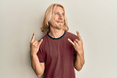 Kafkasyalı, uzun saçlı, taş hareketler yapan, gülümseyen ve kafasını çeviren genç bir adam.. 