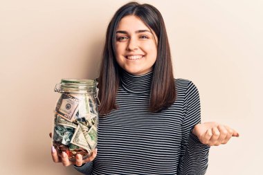 Elinde bahşiş kavanozu tutan genç ve güzel bir kız gururla haykırıyor, zaferi kutluyor ve başarıyı kollarını kaldırarak kutluyor. 