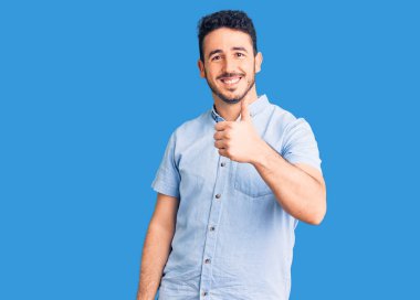 Neşeli ve pozitif gülümseyen İspanyol asıllı genç adam, mükemmel ve onay işareti yapıyor. 