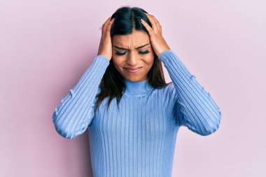 Genç Latin transseksüel kadın gündelik kıyafetler giyiyor. Baş ağrısı çekiyor, çaresiz ve stresli. Çünkü acı ve migren ağrısı var. Eller başının üstünde.. 