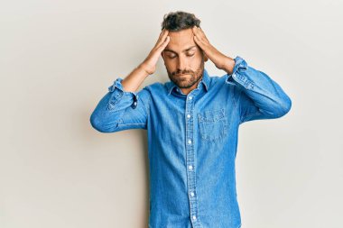 Sakallı, sıradan kot ceketli, eli kafasında yakışıklı bir adam. Stres yüzünden başı ağrıyor. migren ağrısı. 