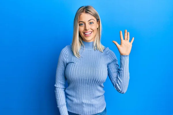 Piękna Blondynka Luźnych Ubraniach Pokazując Wskazując Palcami Numer Pięć Uśmiechając — Zdjęcie stockowe