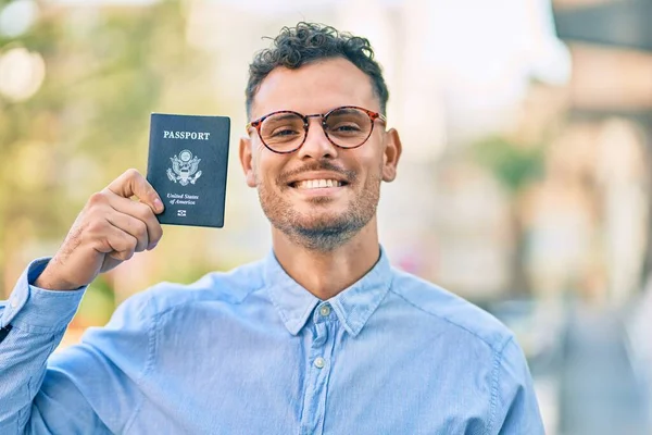 年轻的惊慌失措的商人高兴地微笑着 在城里持着美国护照 — 图库照片