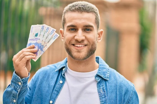 Joven Caucásico Sonriendo Feliz Sosteniendo Pesos Colombianos Ciudad —  Fotos de Stock