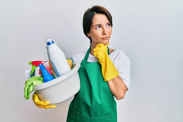 Jovem Morena Com Cabelo Curto Vestindo Avental Segurando Produtos Limpeza — Fotografia de Stock