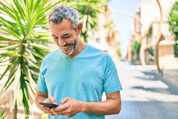 Středního Věku Šedovlasý Muž Úsměvem Šťastný Pomocí Smartphone Chůze Ulici — Stock fotografie