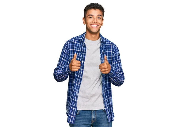 年轻英俊的非洲裔美国男人穿着休闲装 成功的标志着他用手做了一个积极的手势 竖起大拇指 微笑着 快乐地 快乐的表达和胜利的姿态 — 图库照片