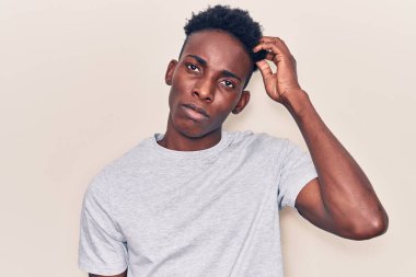 Gündelik giysiler giyen genç Afro-Amerikalı adam soru sorup kafasını karıştırıyor. Şüpheyle kararsız, kafa kafaya düşünerek. Düşünceli kavram. 