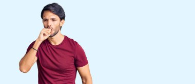 Yakışıklı, günlük kıyafetler giyen, kendini kötü hisseden ve soğuk algınlığı veya bronşitin belirtisi olarak öksüren bir İspanyol. sağlık hizmeti kavramı. 