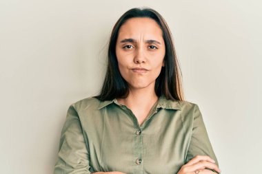 Gündelik kıyafetler giyen genç İspanyol kadın şüpheci ve gergin. Yüzünde çapraz kollu tasvip etmeyen ifade. negatif kişi. 