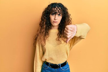 Gündelik kıyafetler giyen genç İspanyol kız mutsuz görünüyor ve reddediliyor ve olumsuz bir hareket yapıyor. kötü ifade. 