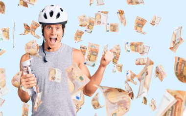 Bisiklet kaskı takan yakışıklı genç adam elinde bir şişe suyla gururla bağırıyor, zaferi kutluyor ve başarıyı kollarını kaldırarak kutluyor.
