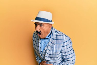 Mide bulantısı, acı verici bir hastalık yüzünden klasik ve şık bir moda tarzı olan bıyıklı olgun bir Orta Doğulu. Ağrı kavramı. 