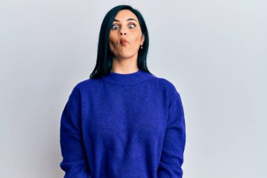 Gündelik kıyafetler giyen genç beyaz bir kadın dudaklarıyla balık suratı yapıyor, çılgınca ve komik bir jest. Komik ifade. 