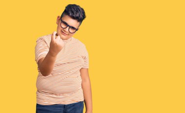 Gündelik kıyafetler ve gözlük takan küçük çocuk seni buraya davet ediyor. Elinle mutlu bir karşılama ve gülümsemeyle gel. 