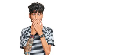 Gündelik kıyafetler giyen genç İspanyol adam yanlışlıkla elleri ile ağzını kapatırken şok oldu. gizli kavram. 