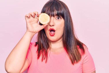 Limon tutan genç ve iri bir kadın. Korkmuş ve ağzı açık kalmış, şaşırmış ve şaşırmış. 