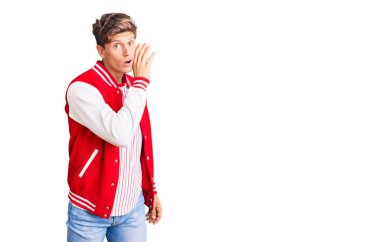 Genç yakışıklı adam beyzbol üniforması giyiyor, elleri ağızda gizli dedikodular söylüyor, kötü niyetli konuşmalar fısıldıyor. 