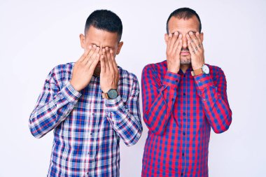 Gündelik kıyafetler giyen, yorgunluk ve baş ağrısı için gözlerini ovuşturan, uykulu ve yorgun ifadeler takınan iki genç gay. görme sorunu 