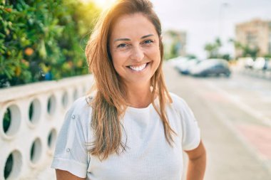 Güzel orta yaşlı İspanyol kadın dışarıda mutlu bir şekilde gülümsüyor.