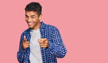 Genç, yakışıklı, Afro-Amerikalı, günlük kıyafetler giymiş, mutlu ve komik yüzüyle kamerayı işaret eden bir adam. iyi enerji ve titreşimler. 