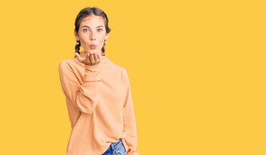 Sarışın, beyaz, sıradan bir kazak giyen güzel bir kadın. Kameraya bakıyor ve havada el ele öpüşüyor. Güzel ve seksi. aşk ifadesi. 