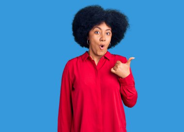 Gündelik giysiler giyen Afro-Amerikan genç kız elleri yana doğru işaret ederek şaşırdı, ağzı açık hayret içinde kaldı.. 