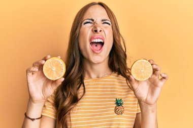 Genç esmer kadın elinde taze turuncu kızgın ve kızgın çığlıklar atan sinirli ve öfkeli, öfkeyle bağıran. 