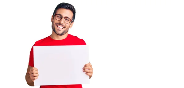 Joven Hombre Hispano Sosteniendo Una Pancarta Vacía Blanco Con Aspecto —  Fotos de Stock