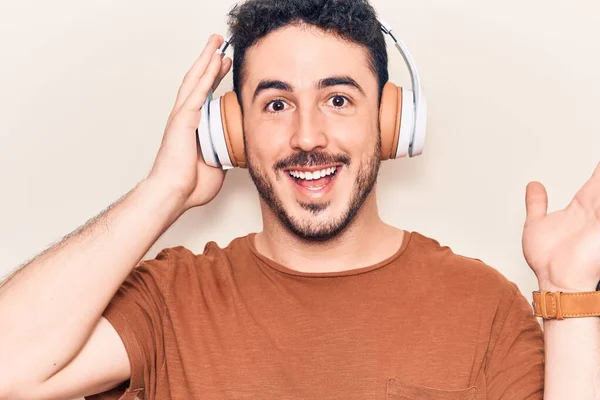 Joven Hispano Escuchando Música Usando Auriculares Celebrando Logros Con Sonrisa —  Fotos de Stock