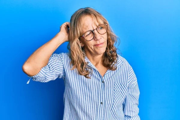 中年金发女人穿着休闲装和眼镜 对问题感到困惑和疑惑 拿不定主意 手拿着头思考 沉思的概念 — 图库照片
