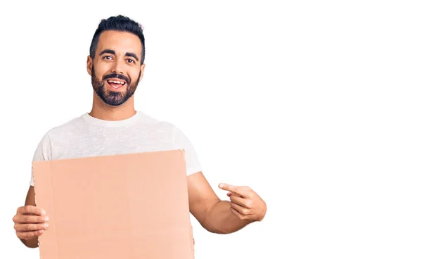 Mladý Hispánec Drží Banner Karton Úsměvem Šťastný Ukazující Rukou Prstem — Stock fotografie