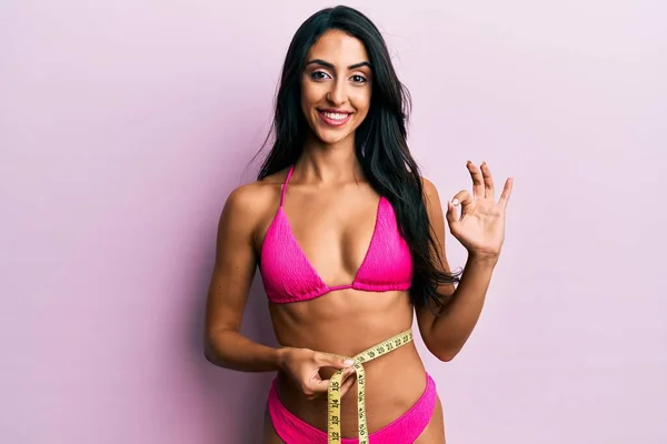 Beautiful Hispanic Woman Wearing Bikini Measuring Waist Doing Sign Fingers — Stock Photo, Image