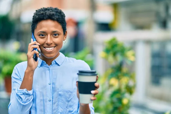 若いアフリカ系アメリカ人の女の子がスマートフォンで話して街でコーヒーを飲んで — ストック写真