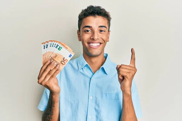 Joven Hombre Afroamericano Guapo Sosteniendo Montón Billetes Euros Sonriendo Con —  Fotos de Stock