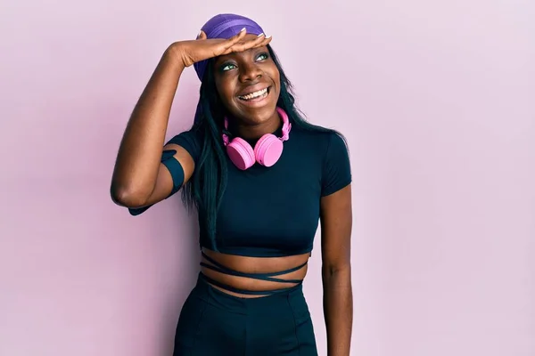 Молодая Африканская Американка Спортивной Одежде Наушниках Счастливая Улыбающаяся Глядя Вдаль — стоковое фото