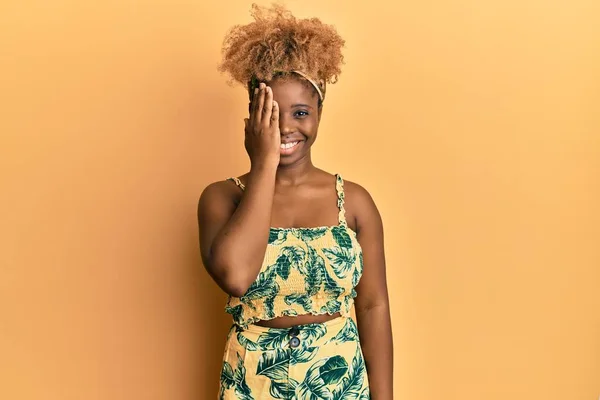年轻的非洲女人 头发是非洲裔 穿着夏装 一只眼睛蒙着 脸上带着自信的微笑 感情令人惊讶 — 图库照片