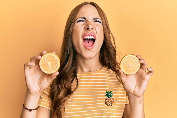 Jovem Morena Segurando Laranja Fresca Com Raiva Louca Gritando Frustrado — Fotografia de Stock